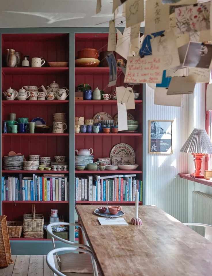 kitchen dining space with open shelving with red shiplap interior, books and crockery, dining table, Farrow & Ball : Asger Mortensen, Wester Agency