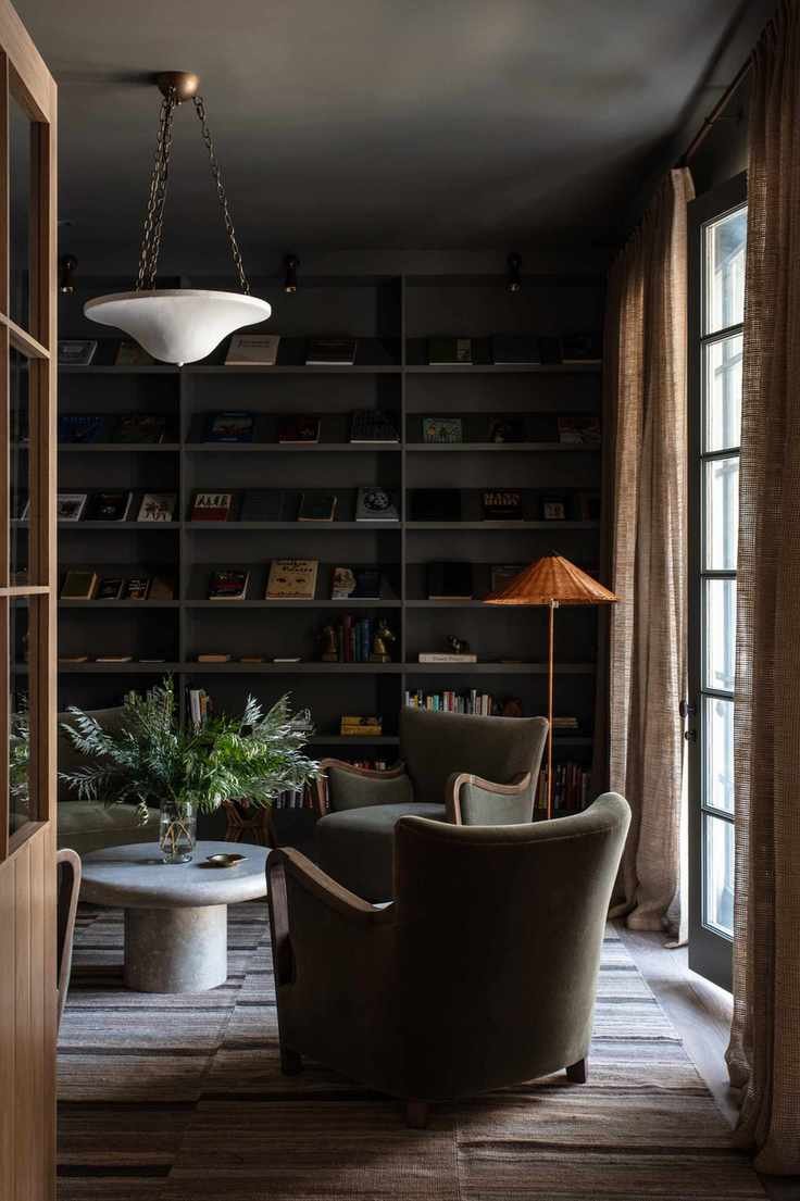 Black shelves, green armchairs, orange lamp