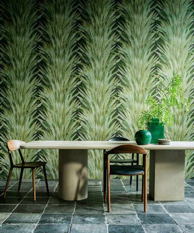 Dining area featuring botanical leaf print wallpaper and a concrete-style table.