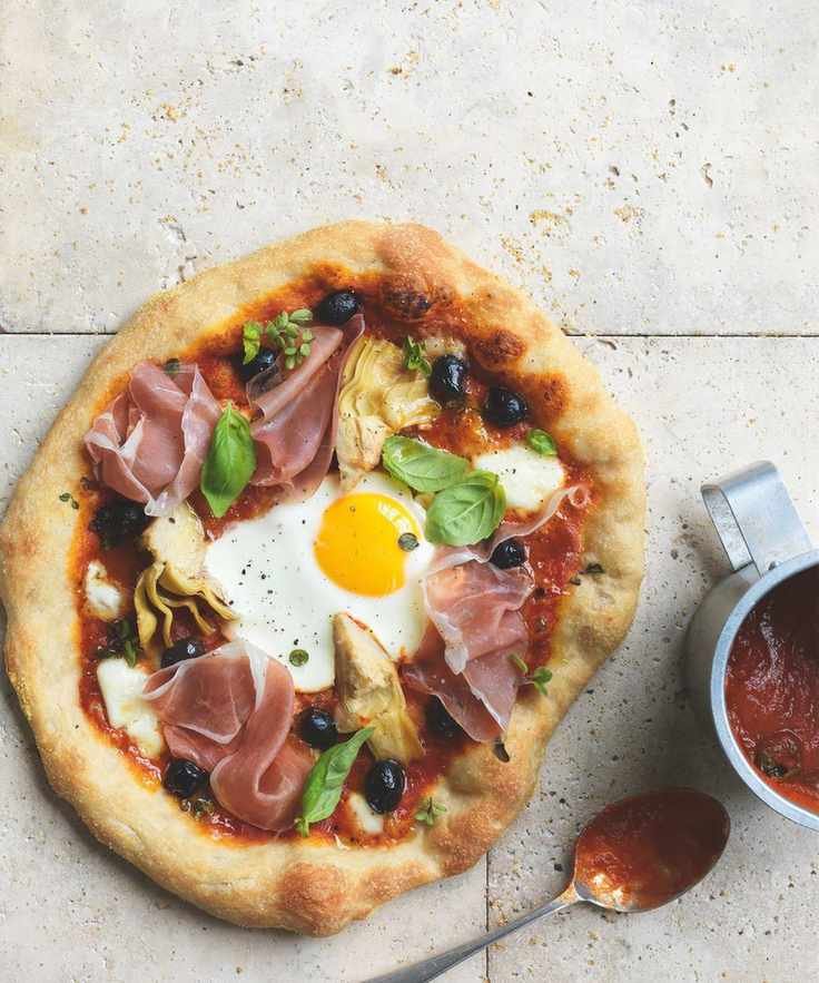 Artichoke, olive and parma ham pizza with an egg on top
