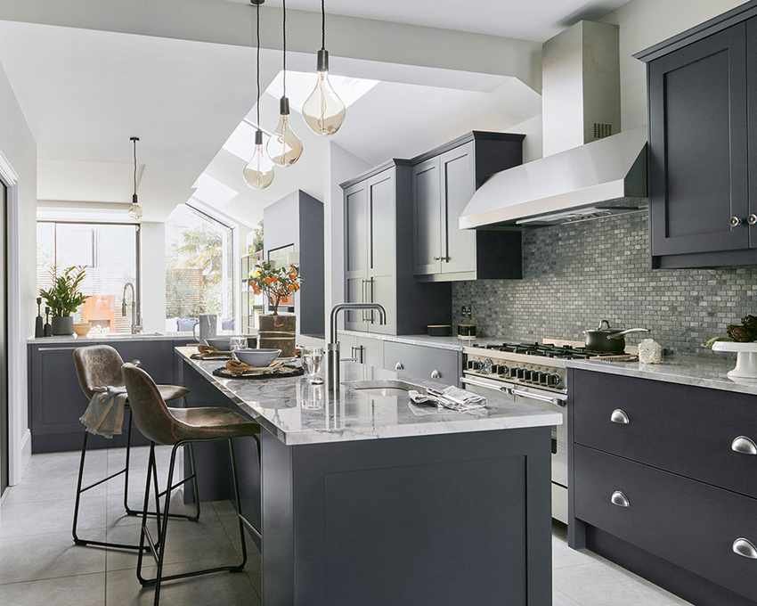 A kitchen extension featuring a large island with brown leather stools