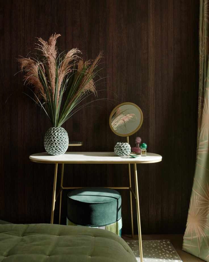 wood panelled bedroom with gold dressing table green throw, green rug and green curtains
