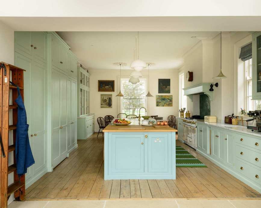 A pale blue kitchen with custom cabinetry and a large kitchen island.