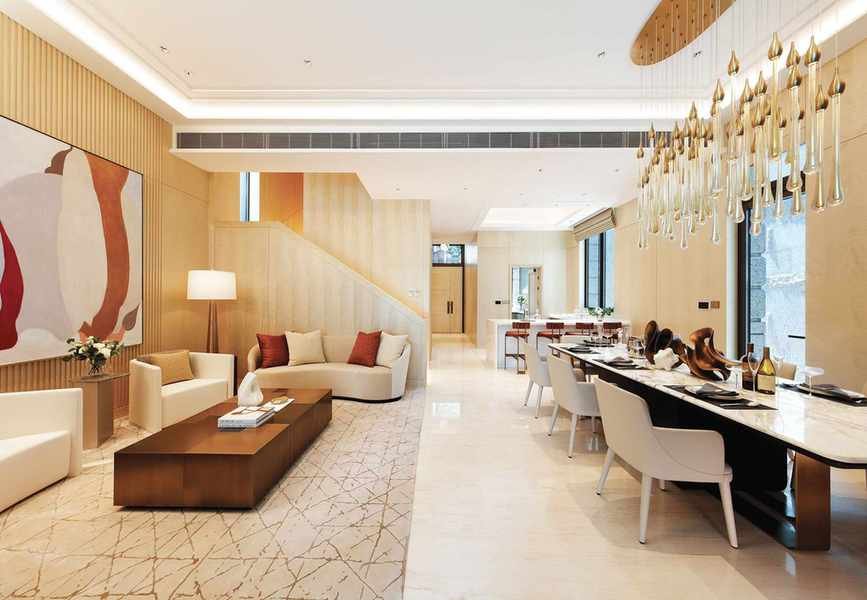 Open plan modern living area with dining zone, sofa area and cream rug and walls