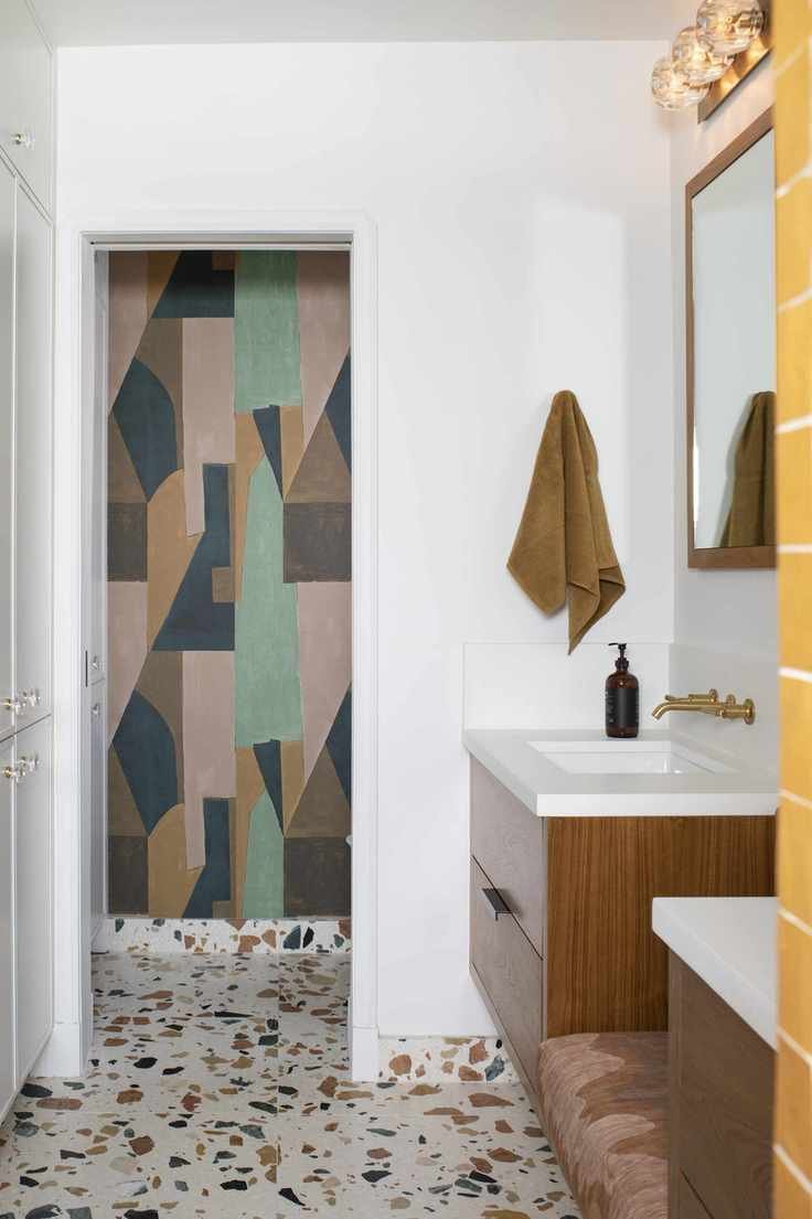 White bathroom with terrazzo floor tiles and wall mural