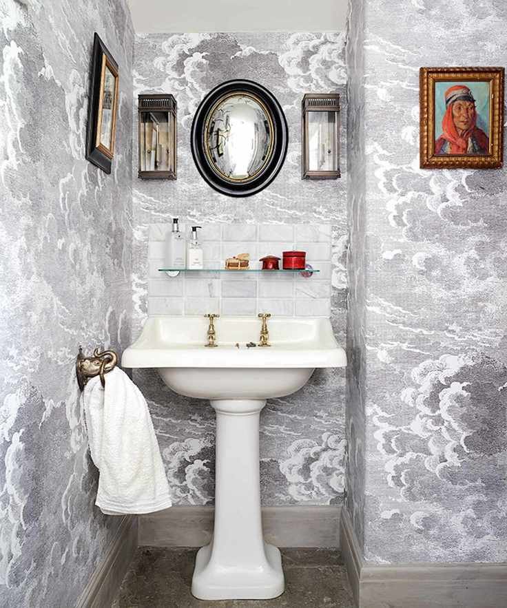 Bathroom artwork mounted on patterned wallpaper.