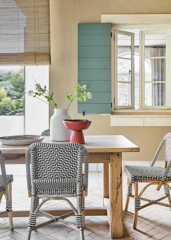 A wooden table with bistro chairs on a brick floor