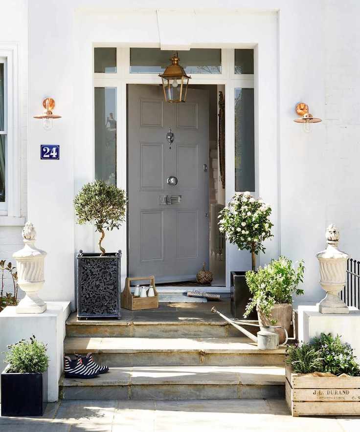 A light grey painted front door set into a white painted home.