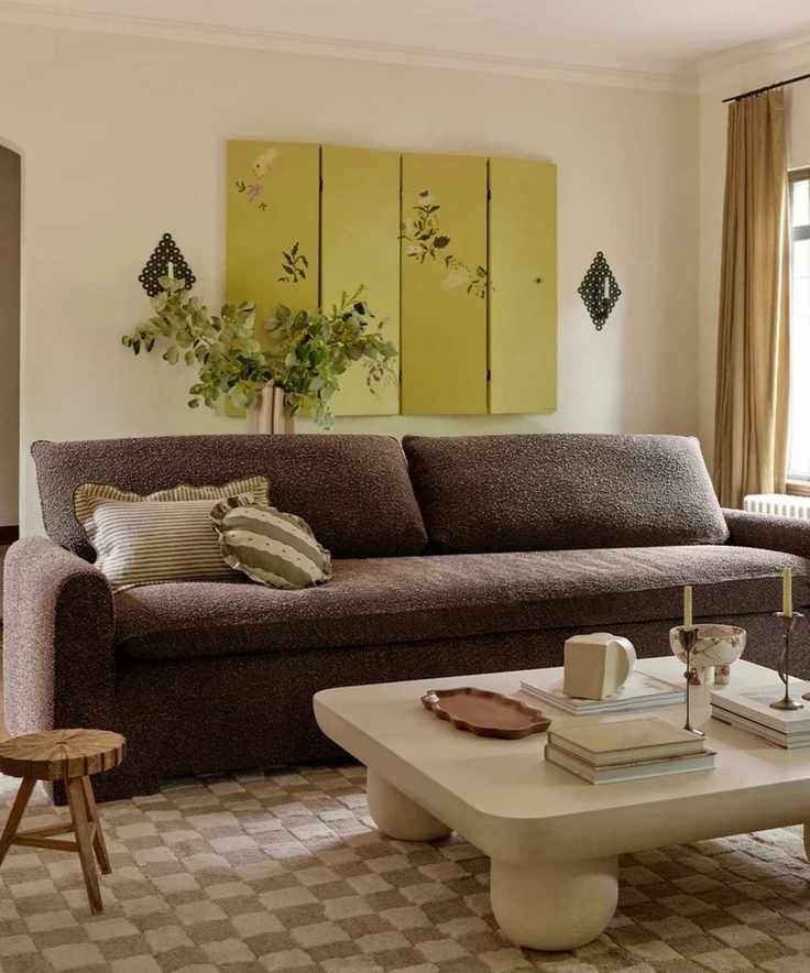 contemporary living room with a chocolate brown boucle couch sat on a checkerboard rug