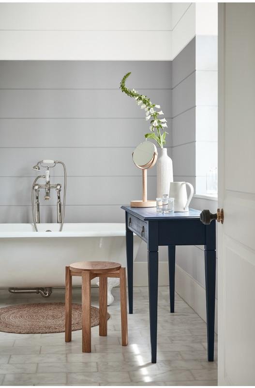 Grey paneling behind a roll-top bathtub