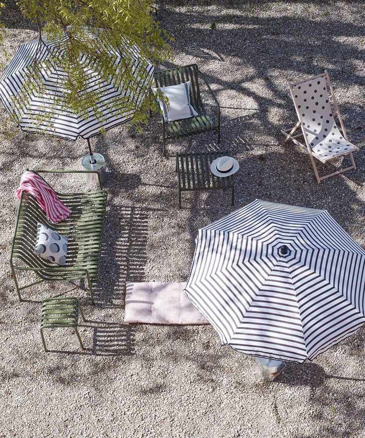 Stylish gravel patio with elegant furniture and a parasol.