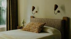 neutral bedroom with modern sconces above the bed