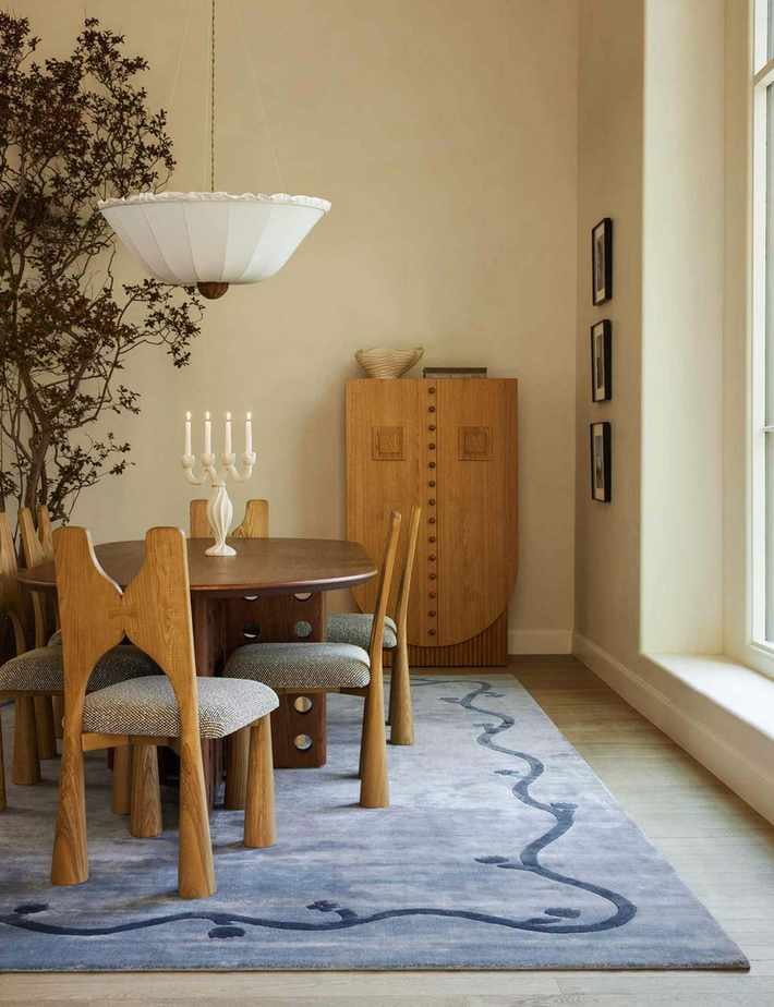 Dining room featuring a blue area rug, wooden dining furniture, and a twisted ceramic candelabra