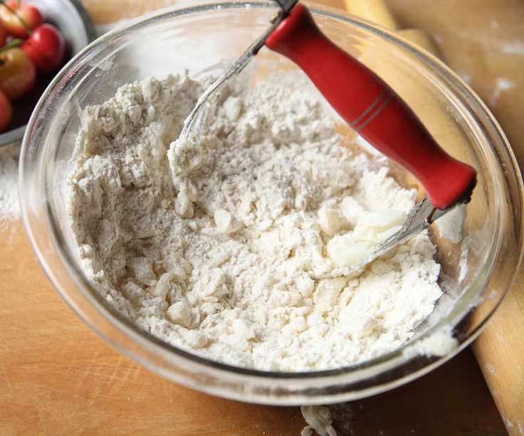 A mixing bowl with a pastry blender making pastry