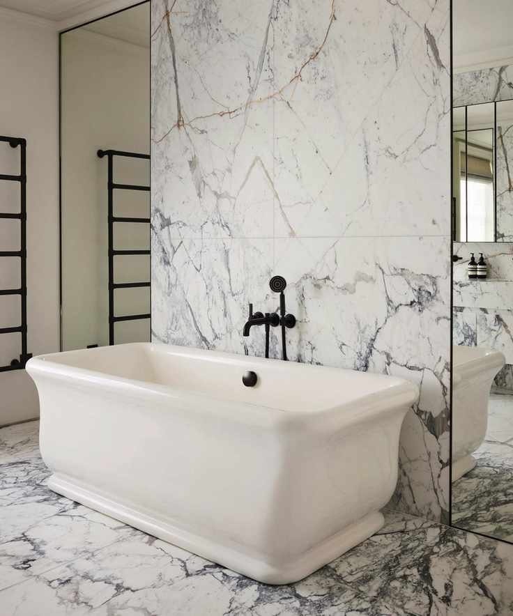 a modern bathroom with extra large marble tiles, freestanding bathtub and mirrored wall panels