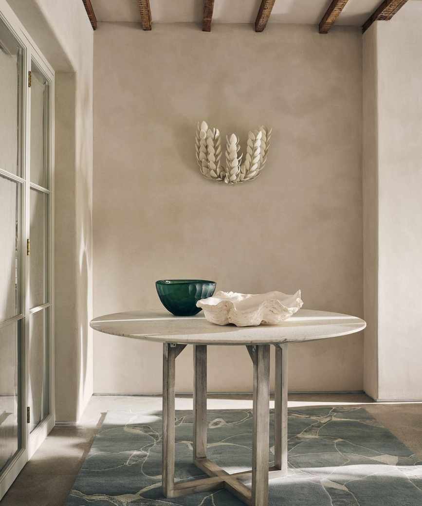 entrance hall with white washed round hall table and decorative wall light