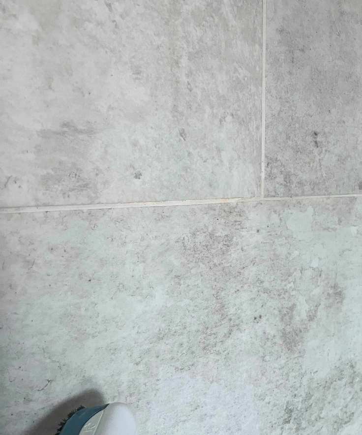 Steam cleaning white grout in grey shower tiles 