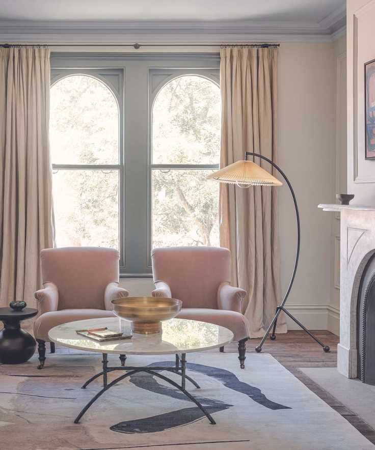 Soft minimalist living room with pink arm chairs and marble coffee table