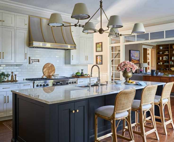 Large modern transitional white kitchen with wood for warmth and flowers on countertops