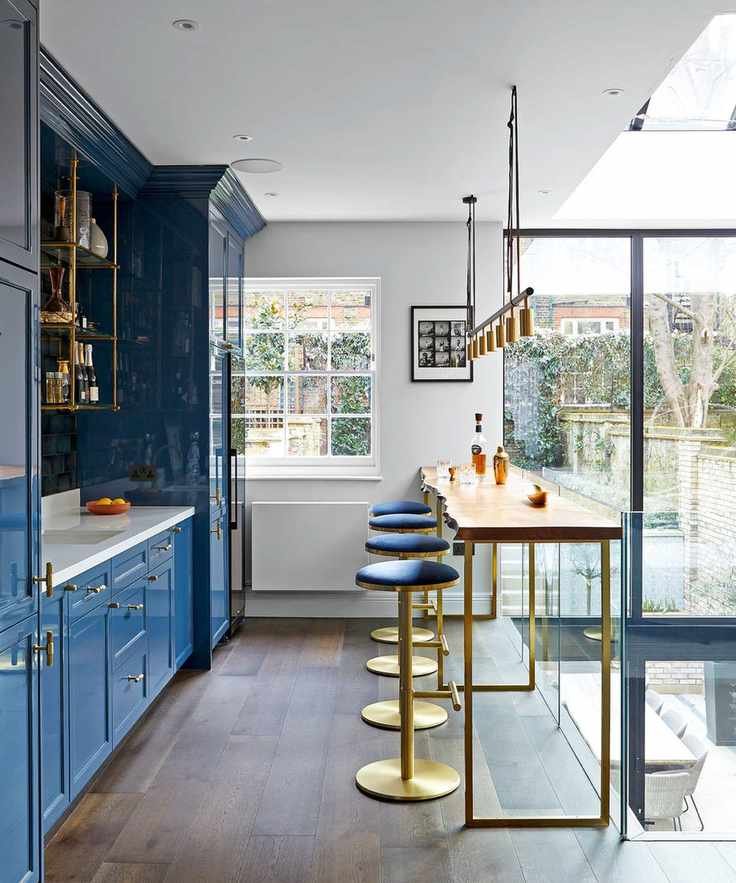 Mezzanine kitchen with blue cabinets and dark wooden floor
