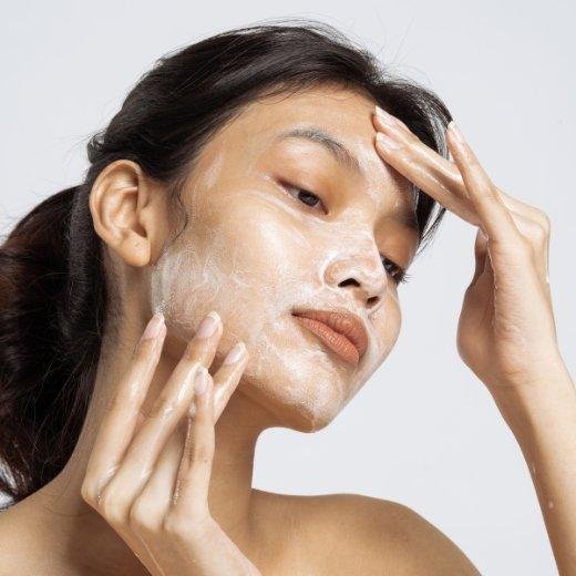 Woman applying gentle cleanser to skin as the first step in her skincare routine