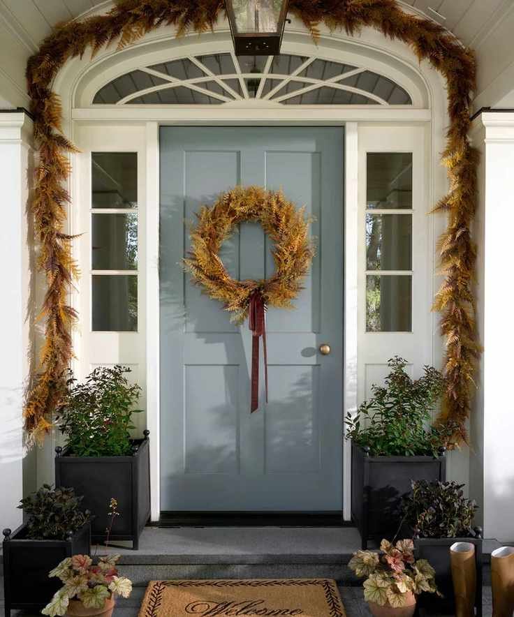 Fall porch with a pale gray door decorated with a fall wreath and fall garland