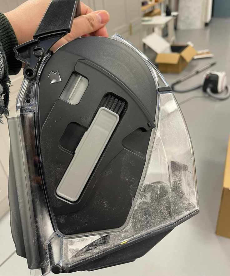Closeup of the Miele Boost CX1 canister vacuum dustbin and small brush in test center