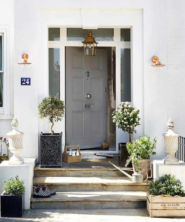 gray front door with two wall lights and one pendant lamp hanging from above