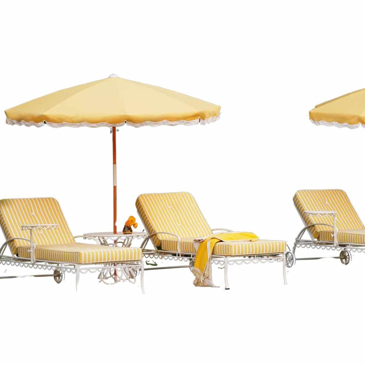 A set of three yellow and white striped sun beds with yellow umbrellas above them