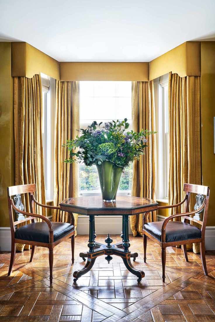 Bay window adorned with full-length curtains and pelmets