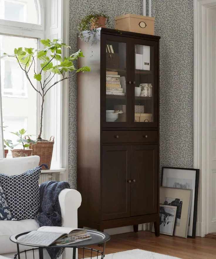Wooden cabinet with printed wallpaper, white sofa and potted plant