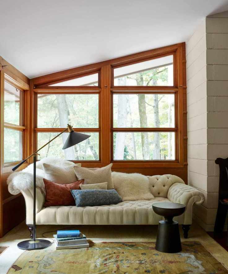Midcentury living room with wood windows, cream sofa and midcentury floor lamp