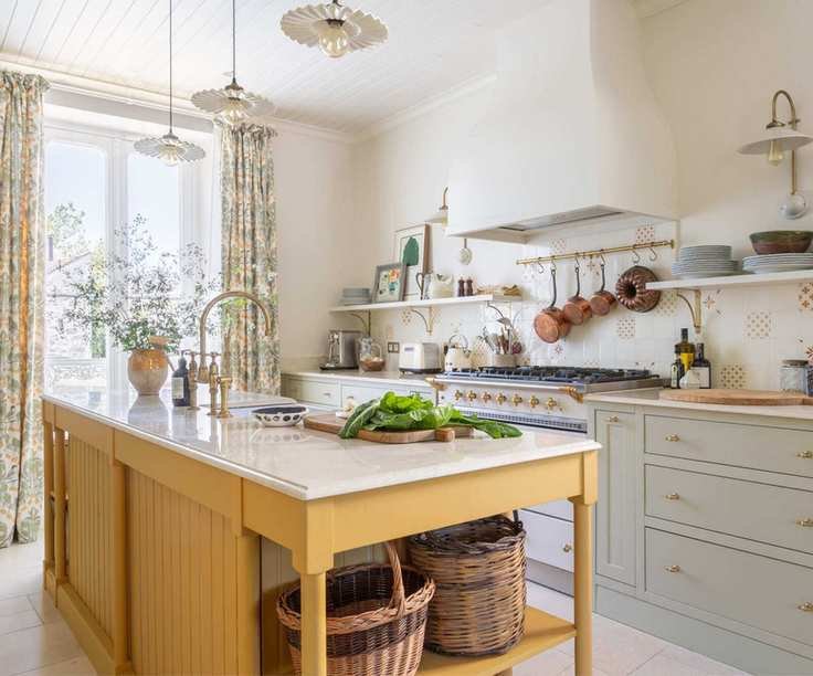 A traditional kitchen with blue cabinets and a yellow island