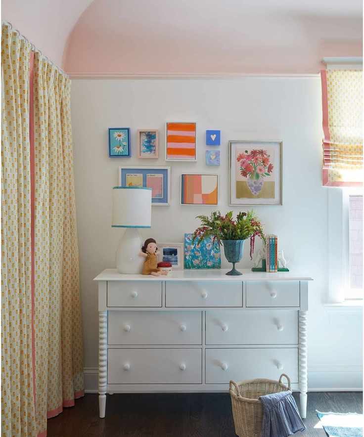 kids bedroom with white walls, pink ceiling, white dresser and gallery wall with colorful artwork