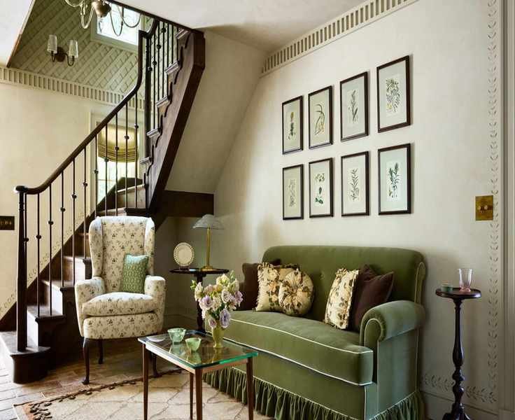 Tonal green living room with a skirted velvet sofa, floral armchair and botanical art