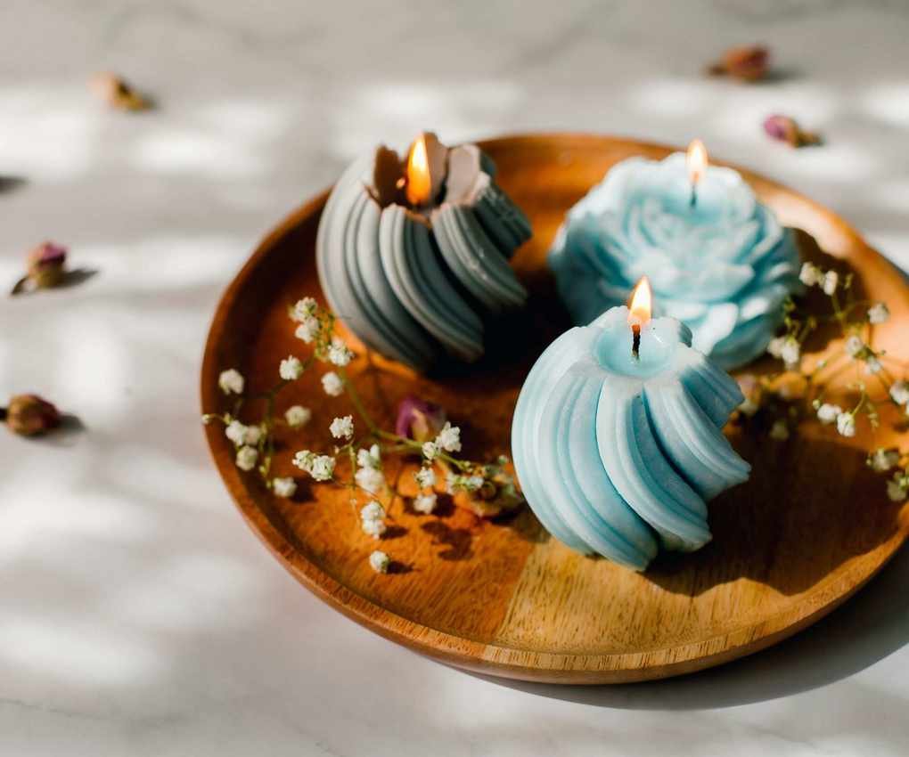 A trio of candles on a wooden plate