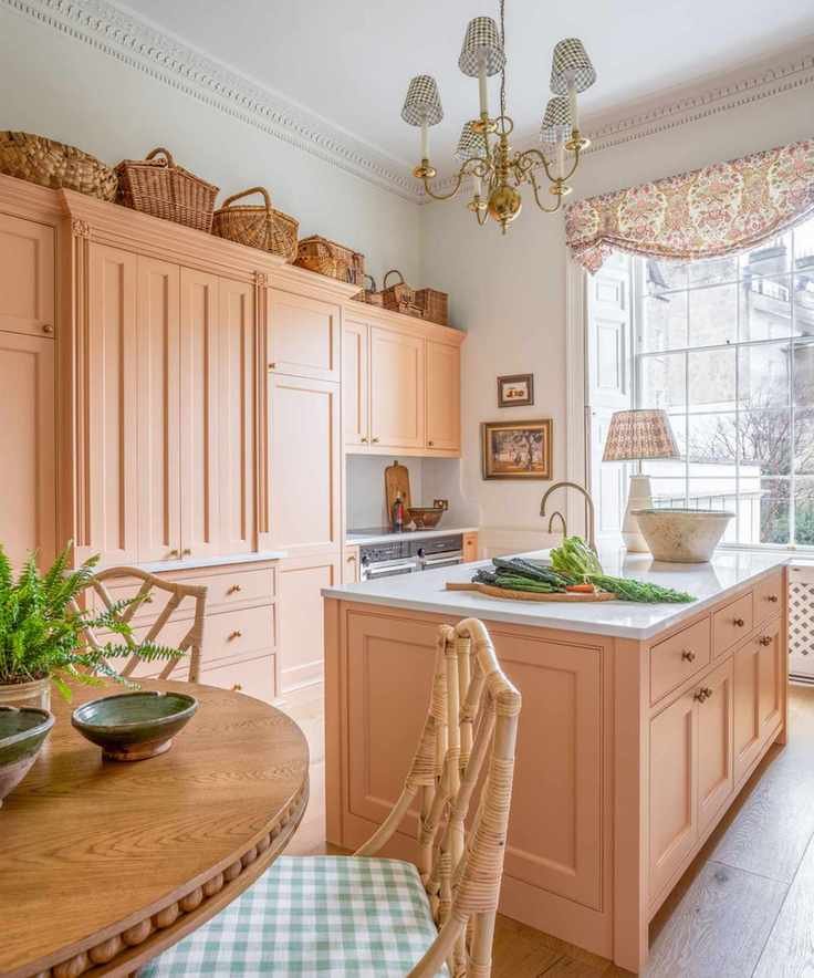 A kitchen with peach pink cabinetry