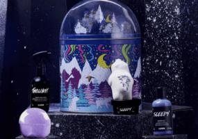 A music box featuring snow-covered mountains is shown alongside bath products.