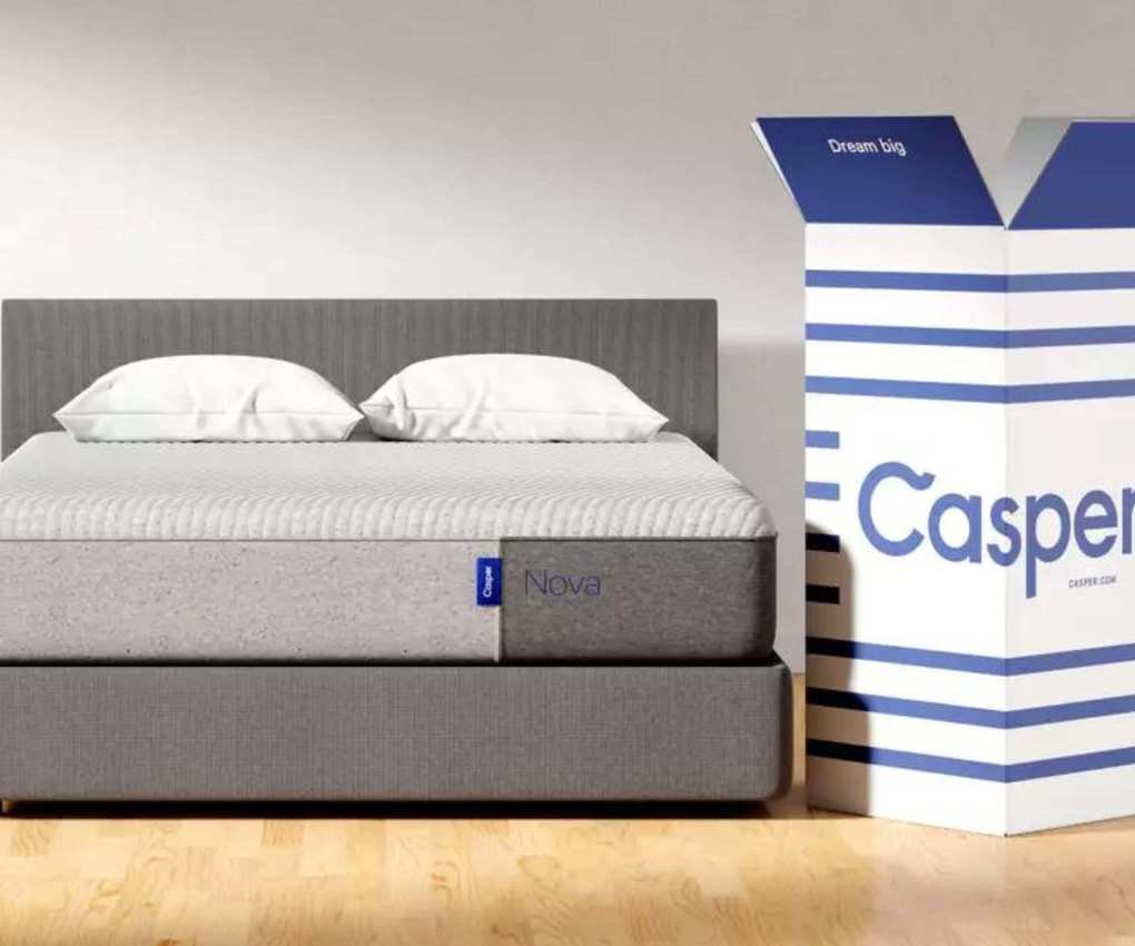 A mattress on a bed with its delivery box.