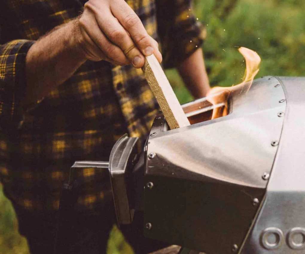 Adding wood into a pizza oven