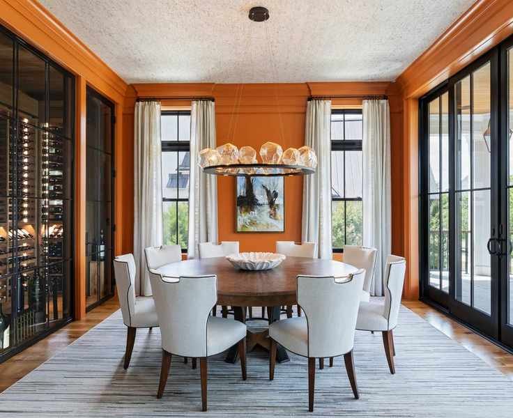 dining room with bright orange walls, traditional furniture and large glass doors