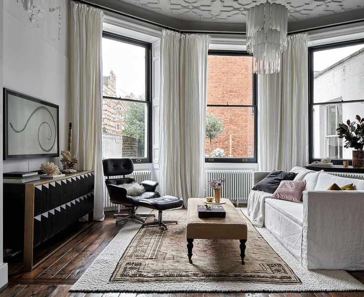 White modern living room with white sofa, tv and patterned rug