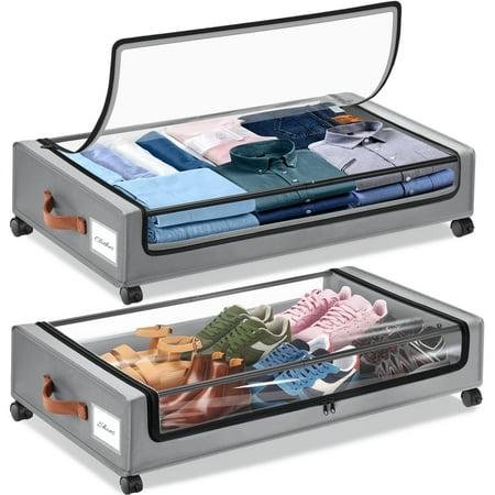 Two gray fabric storage bags for under the bed, on black plastic wheels with clear lids. Shoes in the bottom bag, and folded shirts in the top bag.