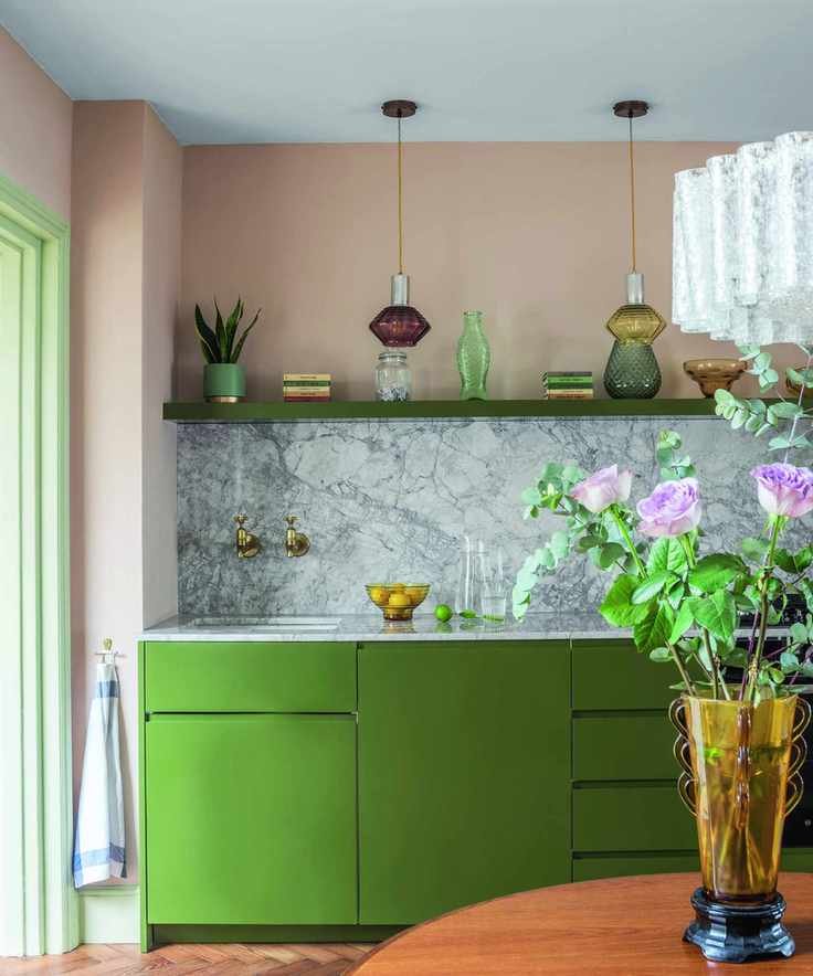 Kitchen with green cabinets and pink walls