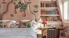 pink bedroom with floral wallpaper and a pink embroidered floral headboard with white bed linens, green bed skirt and upholstered ottoman