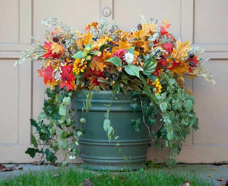 Colorful winter container with lights, fake leaves, green plants