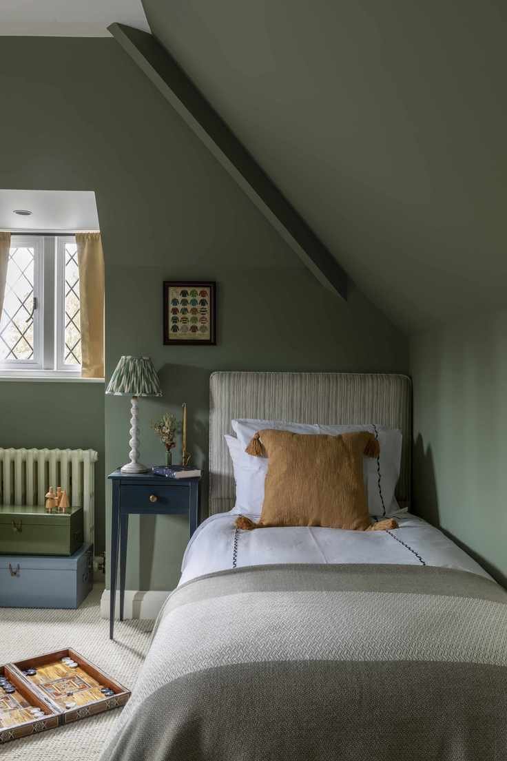 green loft bedroom for kids, single bed, board game, patterned lamp shade, coloured storage chests, blue side table