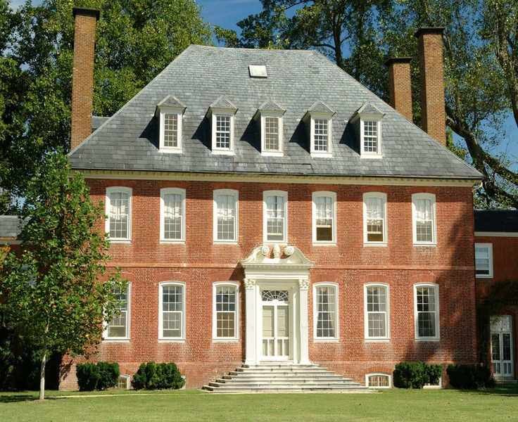 red brick Georgian mansion with chimneys and dormer windows