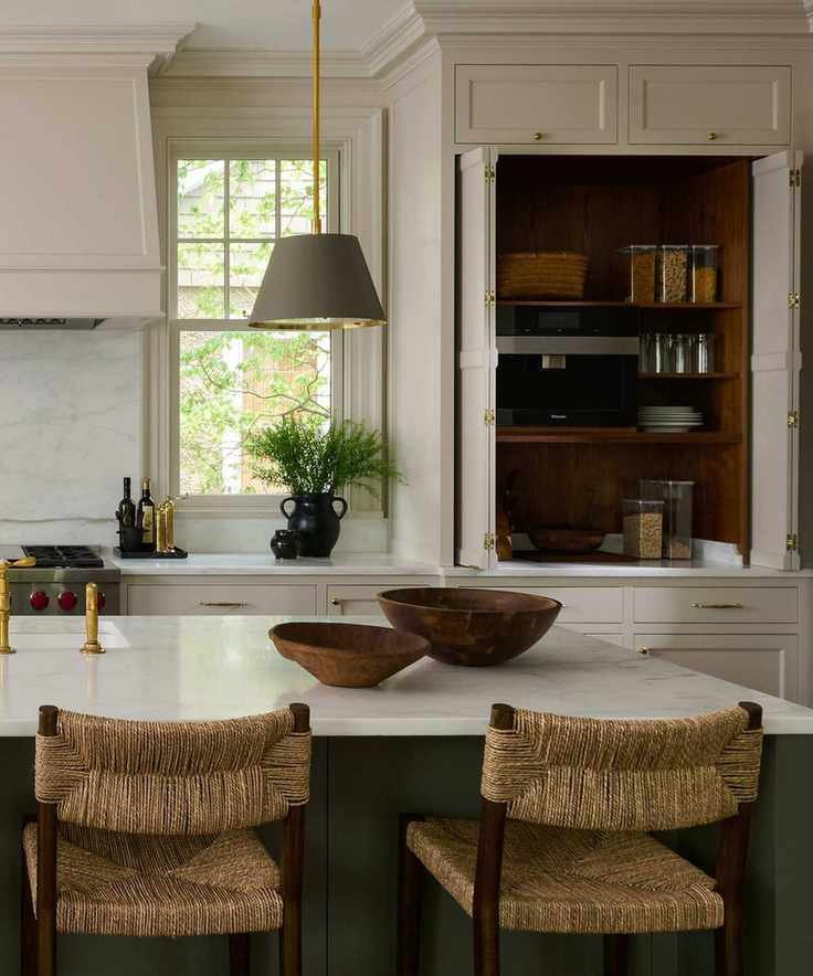 A warm white kitchen with a large cabinet that's been turned into a pantry