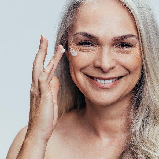 Woman applying moisturizer to dry skin Woman applying moisturizer to dry skin